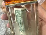 a person holding a glass jar with money inside of it