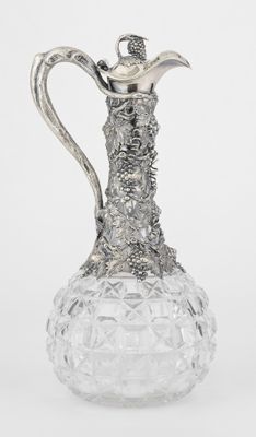 an image of a silver and glass pitcher on a white background