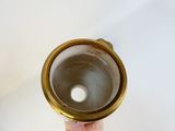 a person holding a gold cup in their hand