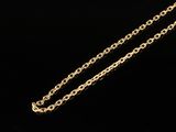 a close up of a gold necklace with a chain on a black background