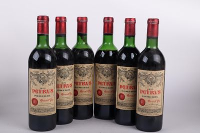 six bouteilles de vin sont alignées sur une surface blanche