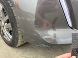 a person holding a remote control in front of a car