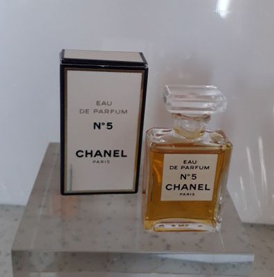 un flacon de parfum Chanel n° 5 et son coffret posés sur une table en marbre