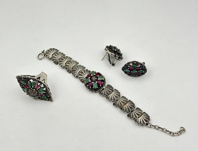 a close up of a bracelet and earrings on a white surface