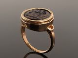 a gold ring with a roman coin embedded into it