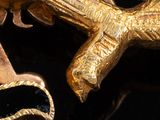 a gold object with a gun on it on a black surface