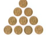 a group of six british gold sovereigns on a white surface