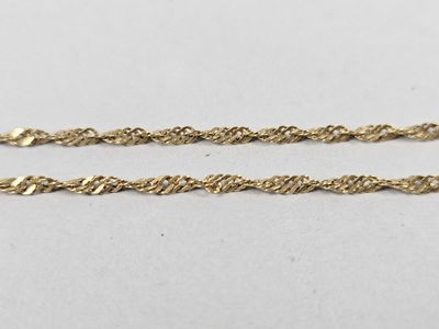 a pair of gold chains on a white surface