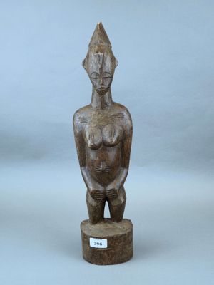 un gros plan sur une statue en bois représentant une femme, posée sur un socle