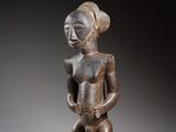 une statue en bois représentant une femme tenant un bébé dans ses bras