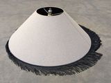 a white lamp shade with a black fringe around it