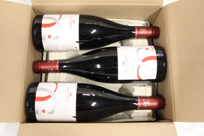 three bottles of wine in a cardboard box on a table