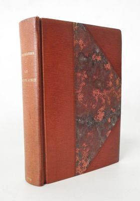 an old book with a red cover sitting on top of a white surface