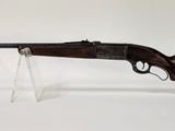un gros plan d'un fusil posé sur un socle transparent, sur fond blanc