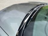 a cat sitting on the hood of a car in the parking lot