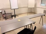 tables and chairs in a room with a projector screen on the wall