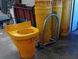 des toilettes jaunes et un seau jaune dans un entrepôt