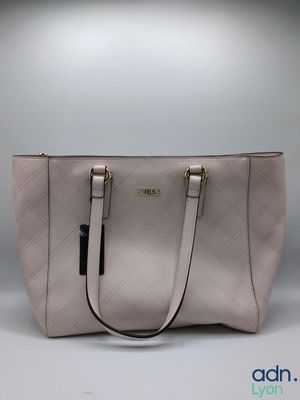 a white purse with a black handle on a grey background