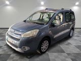 the small blue van is parked on a checkered tile floor