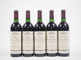 quatre bouteilles de vin rouge sont alignées sur une surface blanche