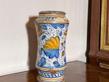 un vase bleu et jaune posé sur un parquet