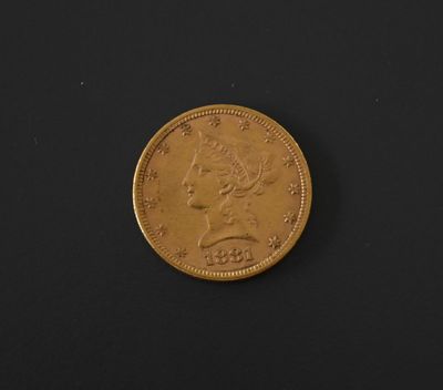 a close up of a gold coin on a black surface