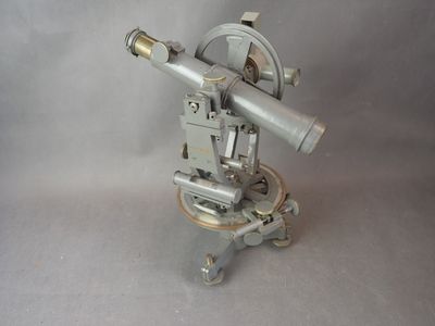 un télescope argenté posé sur un trépied, sur fond blanc
