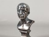 un gros plan sur une statue en argent représentant la tête d'un homme