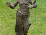 a statue of a boy holding a bird in a field