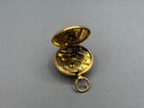 an image of a gold pocket watch on a gray surface