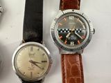 three watches are sitting next to each other on a white surface