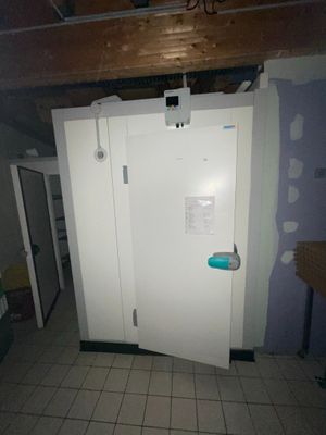 une photo d'un réfrigérateur blanc dans une pièce en cours de rénovation