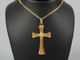 a gold cross necklace with a diamond on a black mannequin