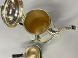 silver plated coffee pot and spoon on a white background