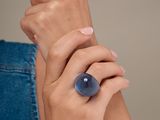 une personne portant une bague sertie d'une pierre bleue