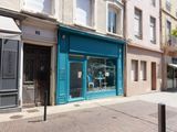 a blue store front on a street corner with buildings in the background