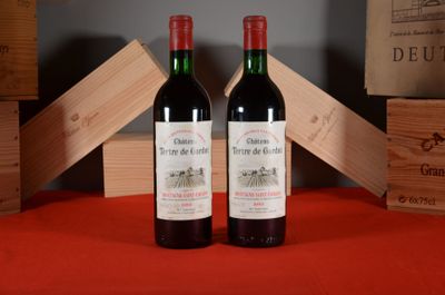 two bottles of wine sitting next to each other on a table