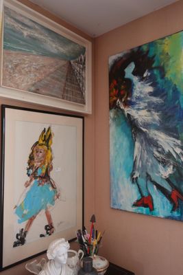 de nombreux tableaux accrochés au mur dans cette pièce