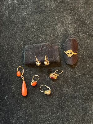 four pairs of earrings and a ring on a black surface