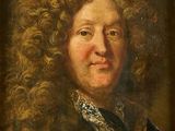 portrait of a man with curly hair in a red coat