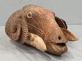 a sculpture of a ram laying down on a white surface