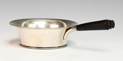une casserole argentée avec une poignée noire sur un fond blanc
