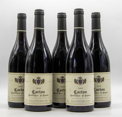 quatre bouteilles de vin sont alignées sur une surface blanche