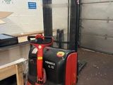 a red fork lift truck parked in a warehouse