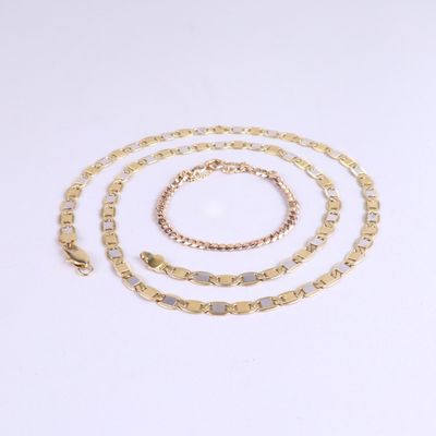 a set of three gold chains and a bracelet on a white background