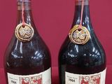 three bottles of wine sitting next to each other on a red surface