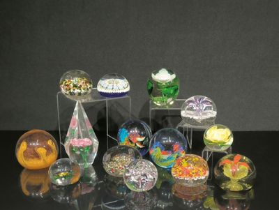 de nombreux objets en verre de différentes couleurs posés sur une table
