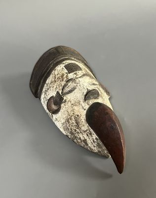 gros plan d'un masque en bois sur une surface blanche