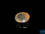 un gros plan d'un diamant sur une surface noire, avec la lune en arrière-plan