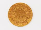 a close up of a gold coin on a white surface